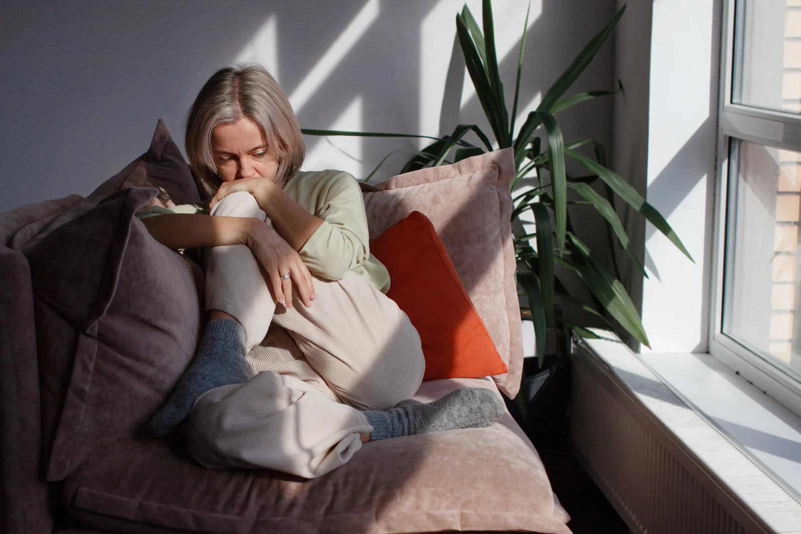 Woman curled up on a sofa – online psychiatry in Hillsboro, OR